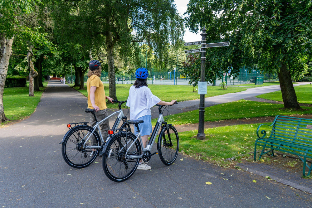Falcon Horizon electric hybrid bikes - riders in a city park — view 14