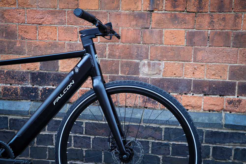 Falcon Zone Electric Hybrid Bike - front end and disc brake against a brick wall — view 23