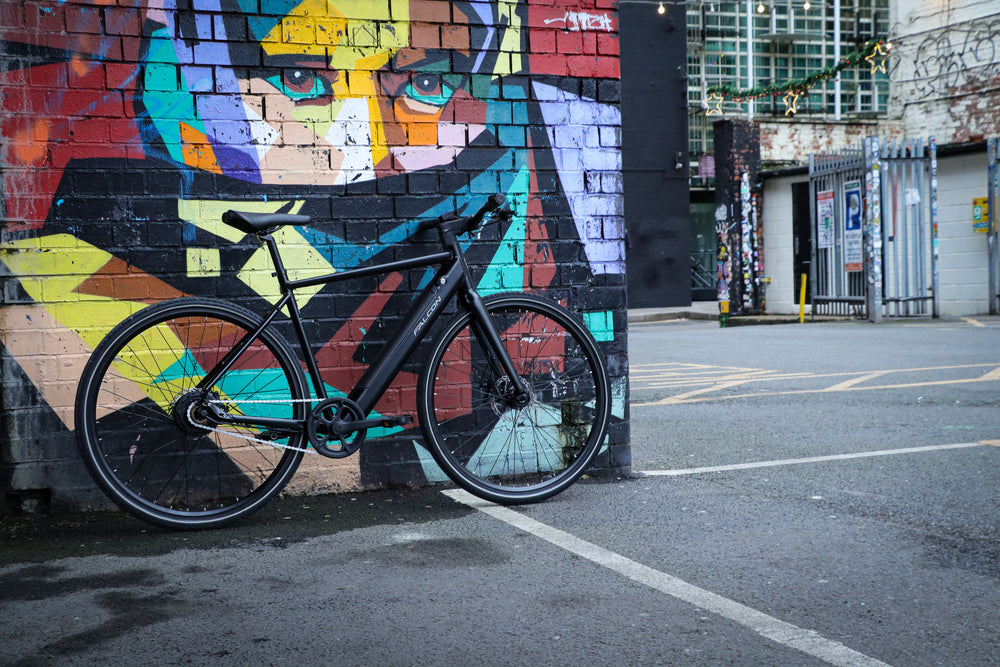Falcon Zone Electric Hybrid Bike - parked by a street art mural — view 30