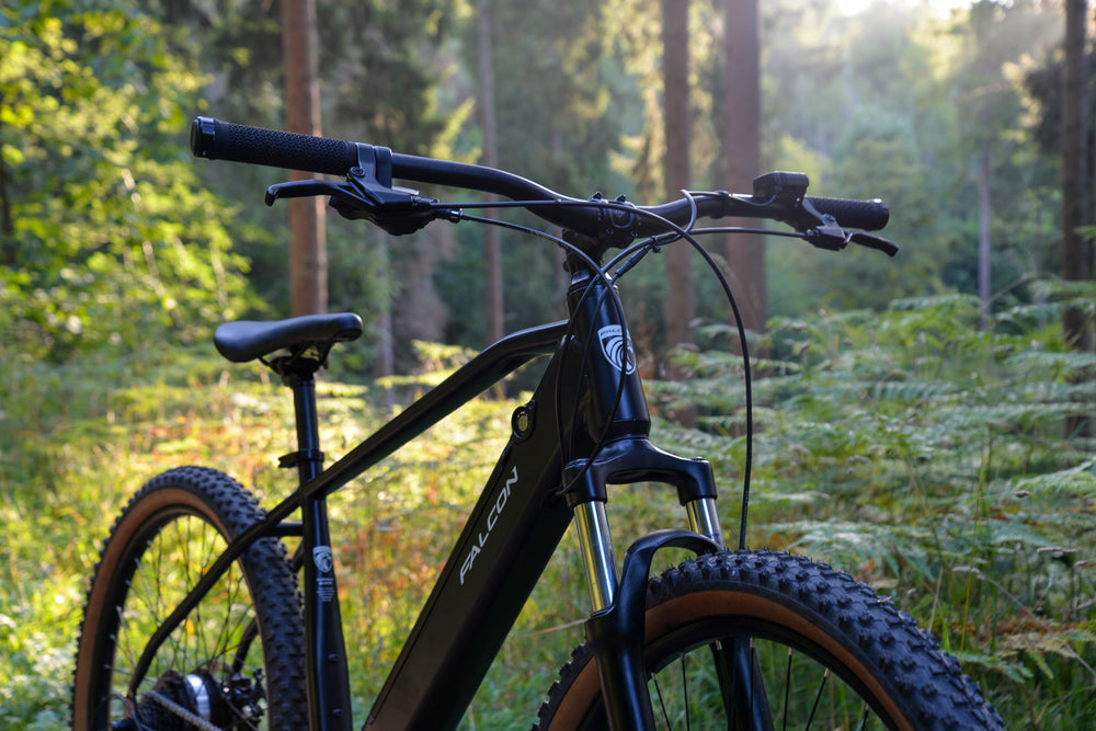 Falcon Turbine Electric Mountain Bike - handlebars and suspension fork in the woods — view 10