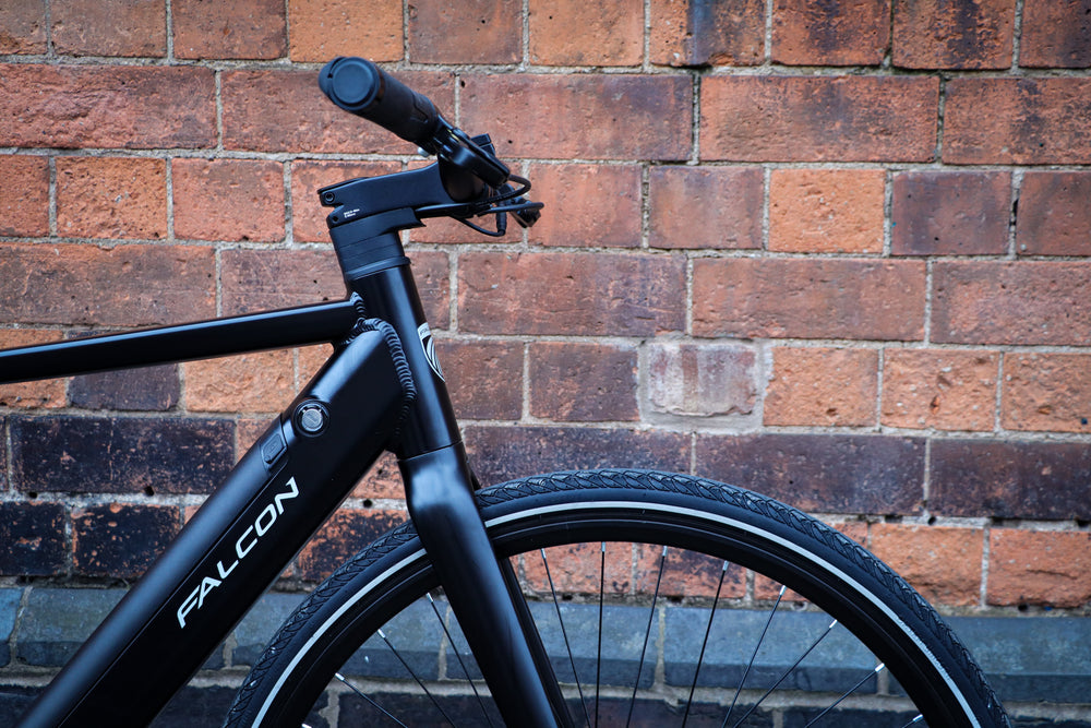 Falcon Zone Electric Hybrid Bike - head tube and handlebars against a brick wall — view 22