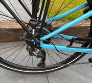 Trek Verve+ 2 rear wheel close-up with Shimano rear derailleur, cassette and chain — view 3